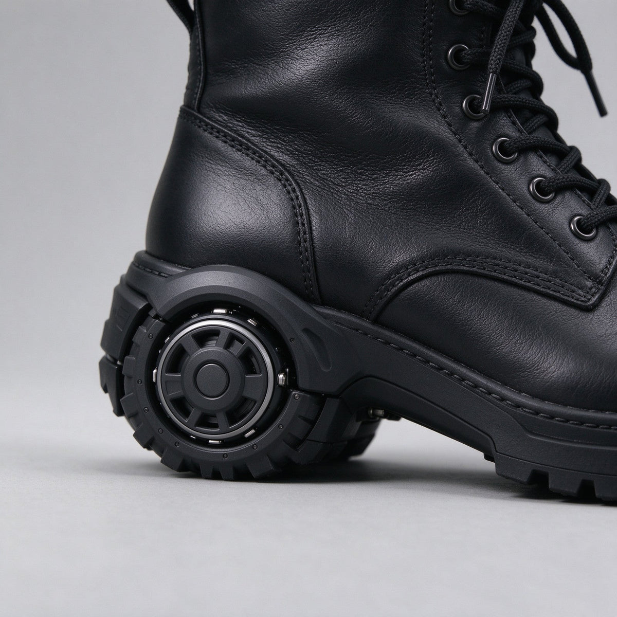 Side view of the black leather combat boot with lug sole and heel wheel